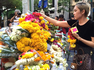 Mourner places flowers at Erawan shrine in central Bangkok
