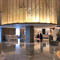 Conrad Bangkok features a brighter lobby with a wat etching above the reception