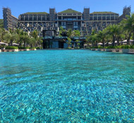 A stunning pool stretches into the distance inviting sun lovers