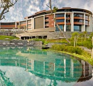 A cascading three-tier pool extends down from the main building