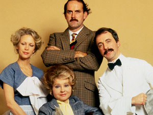 John Cleese a sBasil Fawlty with the cast of British sitcom Fawlty Towers