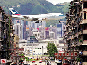 Cathay B747 roars over buildings landing at Kai Tak Airport, Hong Kong's old gateway