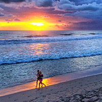 Joggers caught in Seminyak Beach sunset reflections